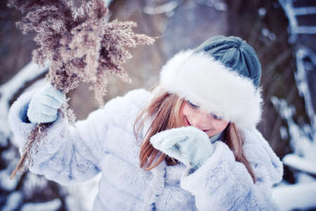 The beautiful girl in a winter snowy parkの写真素材