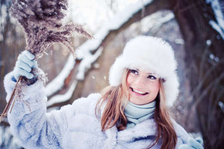 The beautiful girl in a winter snowy parkの写真素材