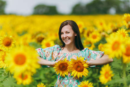 The girl applies sunflower flowers to her breastの写真素材