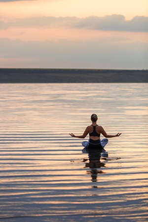 The pretty woman doing yoga at sunset outdoorsの写真素材