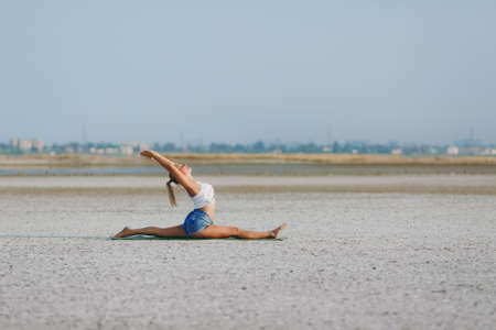 The pretty woman doing yoga on the ground outdoorsの写真素材