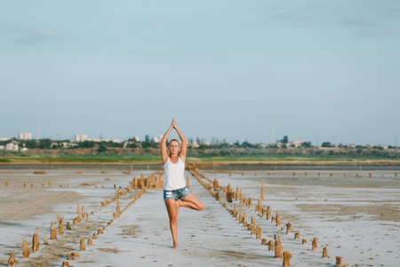 The pretty woman doing yoga on the ground outdoorsの写真素材