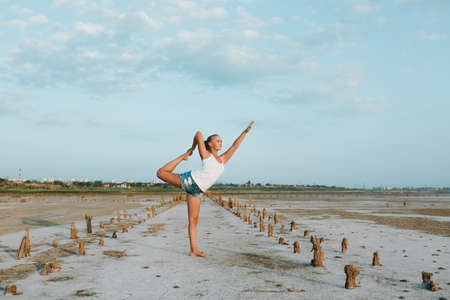 The pretty woman doing yoga on the ground outdoorsの写真素材
