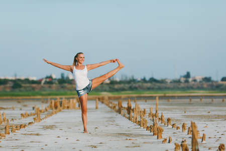 The pretty woman doing yoga on the ground outdoorsの写真素材