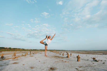 The pretty woman doing yoga on the ground outdoorsの写真素材
