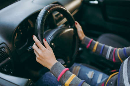 A young European woman with healthy clean skin put her hands with red manicure on her nails on the...