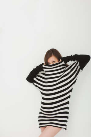 Beautiful fashion pregnant young happy brunette woman in striped black white dress with big belly, tummy. Pregnancy, parenthood, family, motherhood, parents, children, people and expectation conceptの写真素材