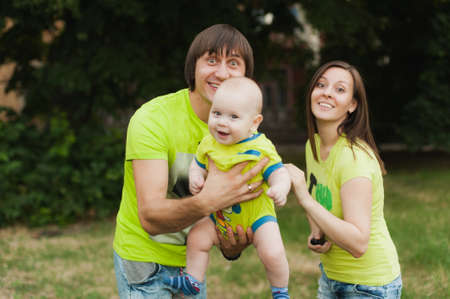 Joyful fun man, woman walking on nature background hugging, playing with little cute child baby boy. Mother, father, little kid son. Parenthood, family day 15 of may, love, parents, children conceptの写真素材
