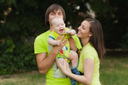 Joyful fun man, woman walking on nature background hugging, playing with little cute child baby boy. Mother, father, little kid son. Parenthood, family day 15 of may, love, parents, children conceptの写真素材