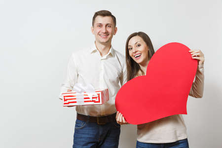 Couple in love. Man and woman with big red heart, present box with gift isolated on white background. Copy space advertisement. St. Valentine's Day International Women's Day birthday holiday conceptの写真素材