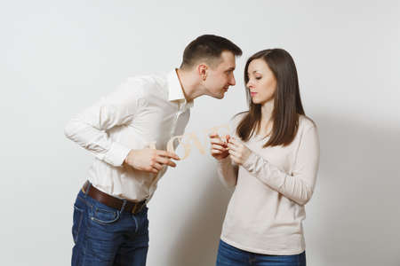 Young cute couple in love. Man and woman with wooden word Love isolated on white background. Copy space for advertisement. St. Valentine's Day International Women's Day birthday holiday conceptの写真素材