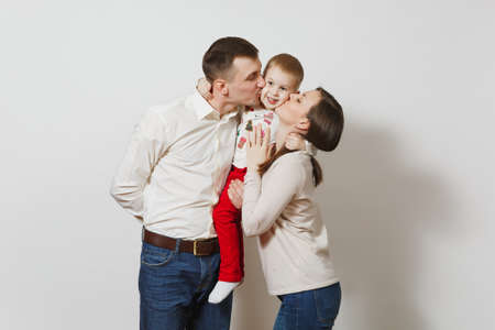 Joyful smiling young man, woman holding, kissing, hugging little cute child boy isolated on white background. Father, mother, little kid son. Parenthood, family day 15 may, parents, children conceptの写真素材