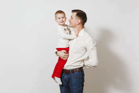 Happy Father's Day. Handsome joyful smiling young man holding and hugging little cute child boy isolated on white background. Father and his little kid son. Parenthood, family and children conceptの写真素材