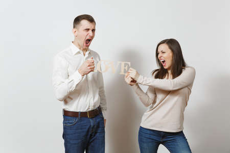 Young couple in love. Man and woman with wooden word Love isolated on white background. St. Valentines Day International Women's Day birthday holiday concept. Quarrel divorce break up of relationshipの写真素材