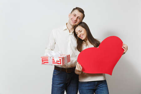 Couple in love. Man and woman with big red heart, present box with gift isolated on white background. Copy space advertisement. St. Valentine's Day International Women's Day birthday holiday conceptの写真素材