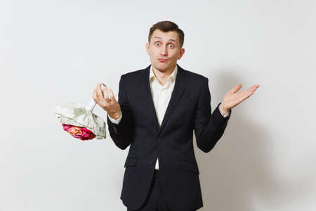 Young handsome perplexed man in suit spreading hands, holding bouquet of beautiful roses flowers isolated on white background. St. Valentine's Day, International Women's Day, birthday holiday conceptの写真素材