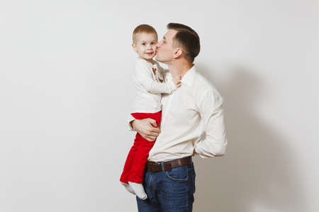 Happy Father's Day. Handsome joyful smiling young man holding and hugging little cute child boy isolated on white background. Father and his little kid son. Parenthood, family and children conceptの写真素材