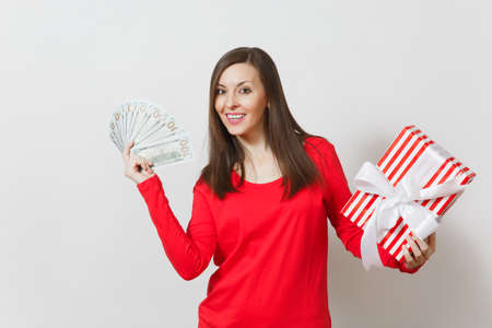 Woman holding bundle cash money dollars, red present box with gift isolated on white background. For advertisement. St Valentine's Day, International Women's Day, Christmas, birthday, holiday conceptの写真素材