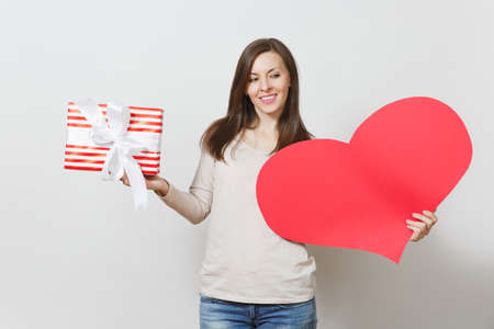 Beautiful young smiling woman holding big red heart in hands isolated on white background. Copy space for advertisement. With place for text. St. Valentine's Day or International Women's Day conceptの写真素材