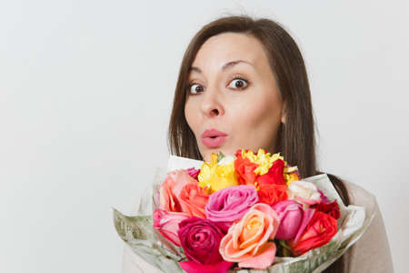 Close up young woman holding bouquet of beautiful roses flowers isolated on white background. Copy space for advertisement. With place for text. St Valentines Day or International Women's Day conceptの写真素材