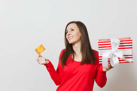 Beautiful woman holding credit card, red present box with gift isolated on white background. For advertisement. St. Valentine's Day, International Women's Day, Christmas, birthday, holiday conceptの写真素材