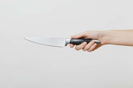 Close up of female hand horizontal holding kitchen knife isolated on white background. Kitchen utensils concept. Copy space for advertisementの写真素材
