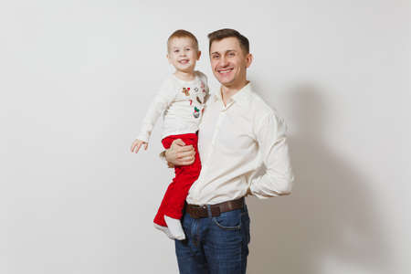 Happy Father's Day. Handsome joyful smiling young man holding and hugging little cute child boy isolated on white background. Father and his little kid son. Parenthood, family and children conceptの写真素材