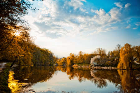 Beautiful natural landscape. A variety of bright orange yellow autumn trees reflected on the surface...