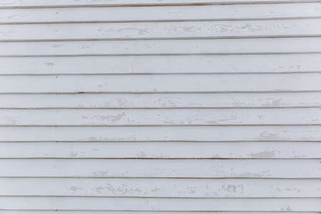 Texture backdrop background white greyish wooden wall from horizontal shabby narrow long boards with scuffs and spots.の写真素材