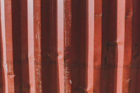 Texture backdrop background bright red orange metal fence with damages, scratches, bumps and depressions.の写真素材