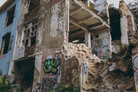 Odessa, Ukraine, 10-12-2017:Industrial building of with graffiti and street art on shabby walls and piles of bricks destroyed as war, earthquake, bomb, terrorist attack or natural disaster concept.のeditorial素材