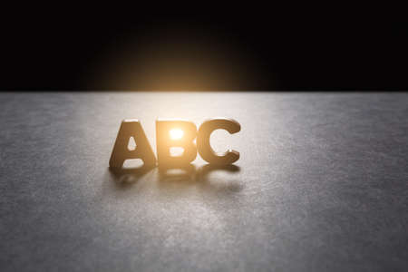 Letters ABC of wooden letters on the dark texture with a black background with backlight. Lighting effect.の写真素材
