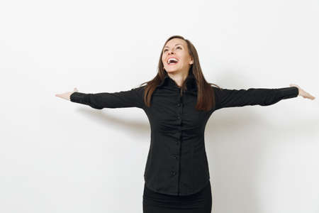 Beautiful happy caucasian young smiling brown-hair business woman in black classic shirt and skirt spreading hands isolated on white background. Manager or worker. Copy space for advertisementの写真素材