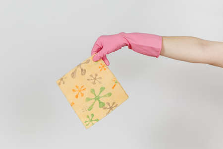 Close up of female hand in pink gloves horizontal holds patterned orange rag for cleaning and washing dishes isolated on white background. Cleaning supplies concept. Copy space for advertisement.の写真素材