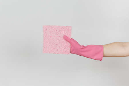 Close up of female hand in pink gloves horizontal holds pink absorbent napkin for cleaning and washing dishes isolated on white background. Cleaning supplies concept. Copy space for advertisement.の写真素材