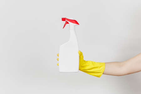 Close up of female hand in yellow gloves holds white spray bottle with cleaner liquid with place for...