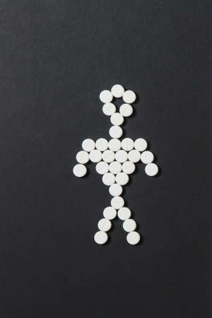 Medication white colorful round tablets arranged abstract on black background. Human, aspirin, capsule pills design. Treatment, choice healthy lifestyle concept. Copy space for advertisementの写真素材