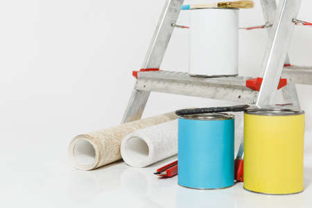 Instruments for renovation apartment room isolated on white background. Wallpaper and accessories for gluing, painting tools. Colorful paint cans. Concept of repair home. Copy space for advertisementの写真素材