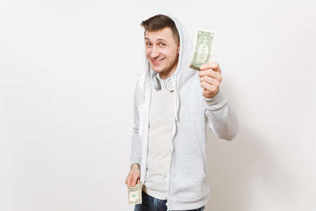 Young handsome smiling student in t-shirt, blue jeans and light sweatshirt with hood with headphones...