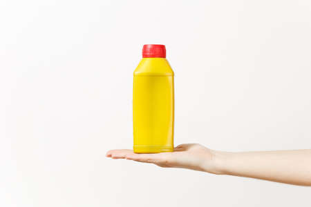 Close up of female hand horizontal holds yellow empty blank bottle with copy space isolated on white...