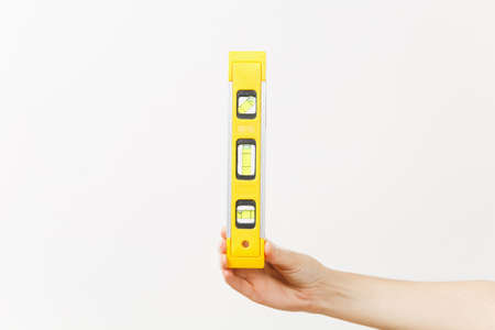 Close up of female hand vertical holds building bubble spirit level isolated on white background....