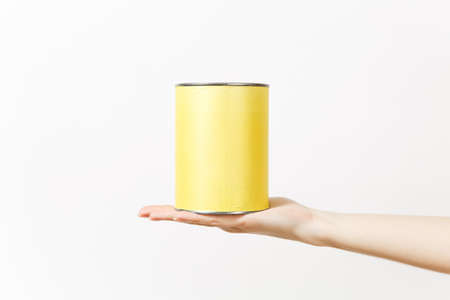 Close up of female hand horizontal holds empty paint tin can with copy space isolated on white...