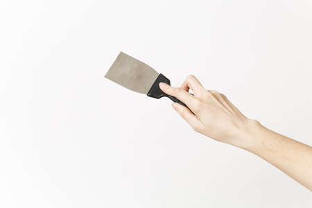 Close up of female hand horizontal holds putty knife isolated on white background. Instruments,...