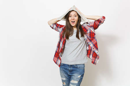 Young shocked overjoyed beautiful woman in newspaper hat clinging to head isolated on white...