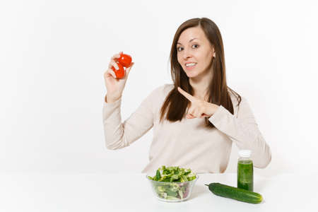 Woman at table with green detox smoothies, fresh salad in glass bowl, tomato, cucumber isolated on white background. Proper nutrition, vegetarian food, healthy lifestyle, dieting concept. Copy spaceの写真素材