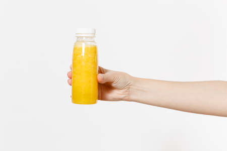 Close up female holding in hand yellow detox smoothies in bottle isolated on white background.
