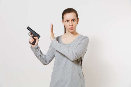 Woman with gun in hand showing stop gesture with palm isolated on white background.
