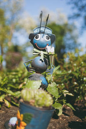 One decorative garden funny cute sweet ant in hat, bow tie with shovel in flower pot with cactus decorating yard.の写真素材