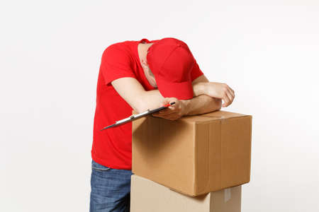 Delivery man in red uniform isolated on white background. Male courier in cap, t-shirt holding pen, clipboard with papers document, blank empty sheet, cardboard box. Receiving package. Copy spaceの写真素材
