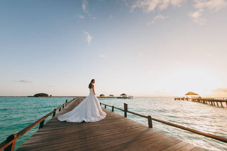 The beautiful bride on a pier near water bungalowsの写真素材